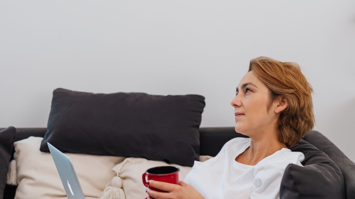 Person relaxing on a couch with a laptop