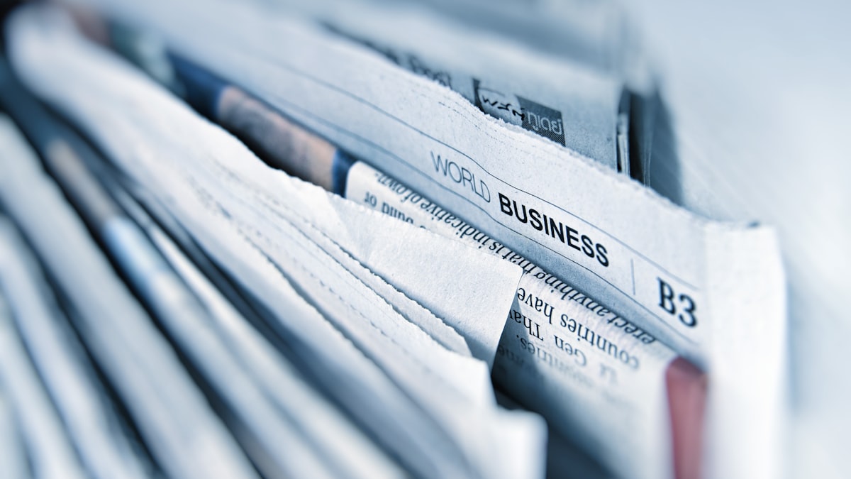 A stack of newspapers with world business headlines